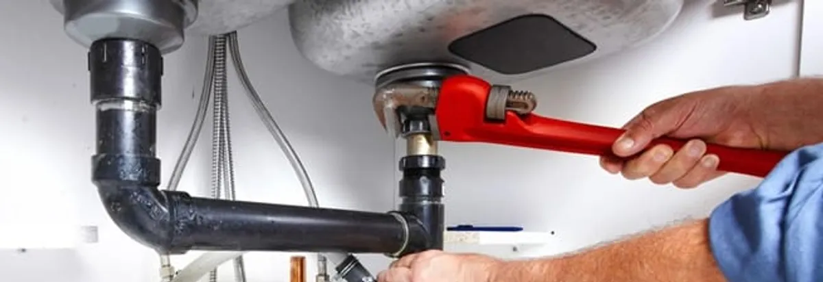 Garbage disposal repair technician tightening the sink drain and disposal connection in Lakeland, FL