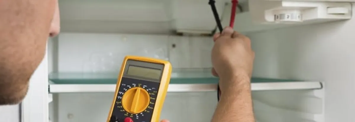 Refrigerator repair technician testing electrical components with a multimeter in Lakeland, FL