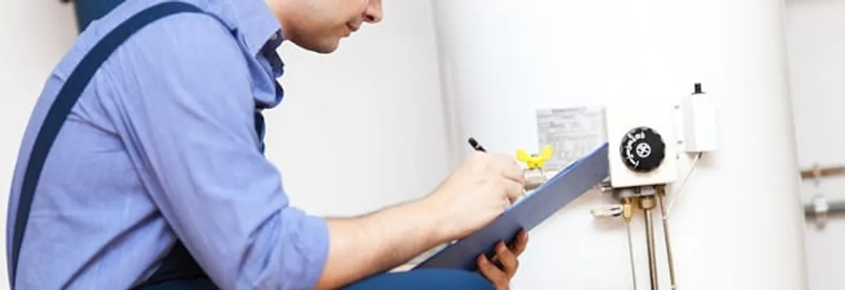 Water heater repair technician inspecting the unit and recording service notes in Lakeland, FL